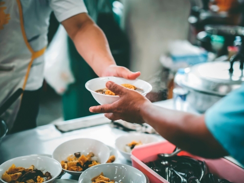 two hands holding a bowl of food